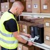 Warehouse worker using Brother industrial label printer to print shipping labels