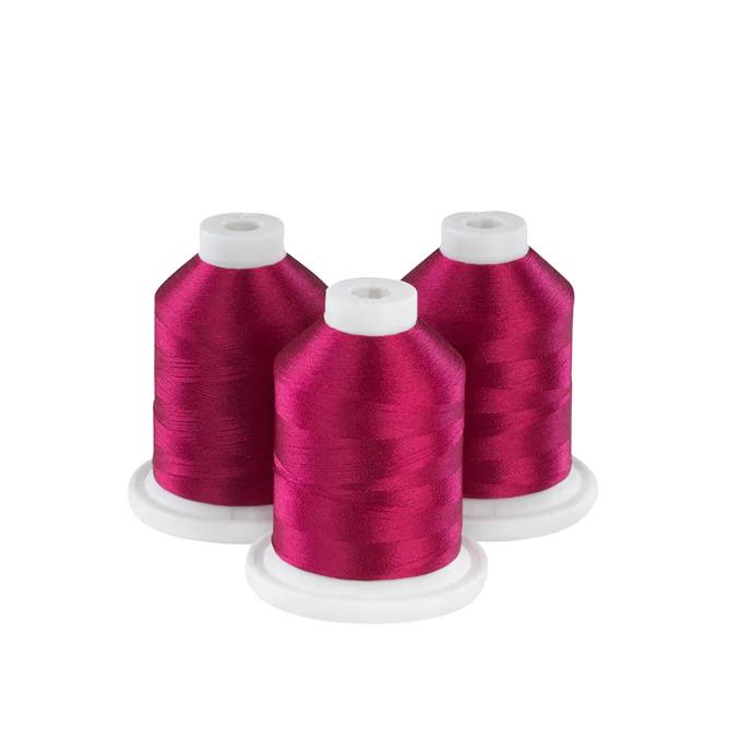 Three garnet rose embroidery thread spools on white bases