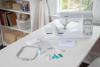 Brother Innovis NS1250E sewing and embroidery machine on white desk with accessories