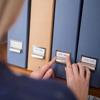 Person selecting labeled file storage box from organized shelf system