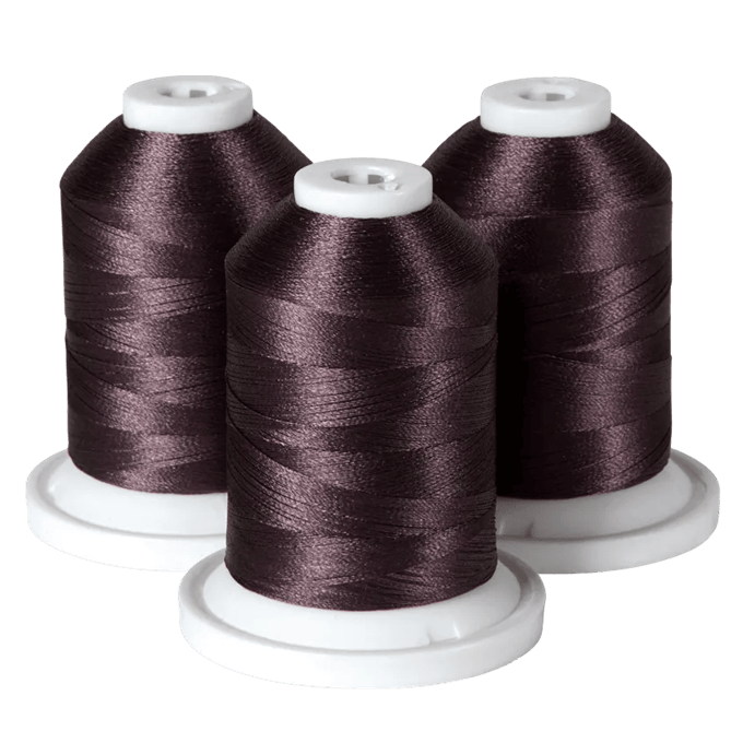 Three spools of dark brown embroidery thread on white bases