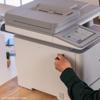 Hand inserting USB drive into Brother MFC all-in-one printer with touchscreen display