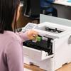 Woman replacing toner cartridge in Brother HL-EX415DW wireless laser printer in office