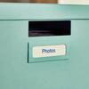 Etiqueta laminada Brother TZe-243 en organizador de archivos verde menta con texto Photos