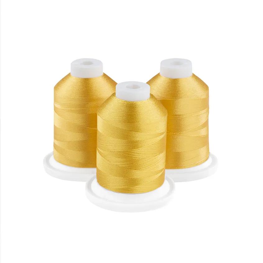 Three spools of golden yellow embroidery thread with white caps on white bases