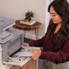 Woman loading paper into Brother MFC-L8970CDW color laser all-in-one printer in home office