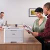 Brother HL-L5215DW monochrome laser printer in modern office with colleagues reviewing documents