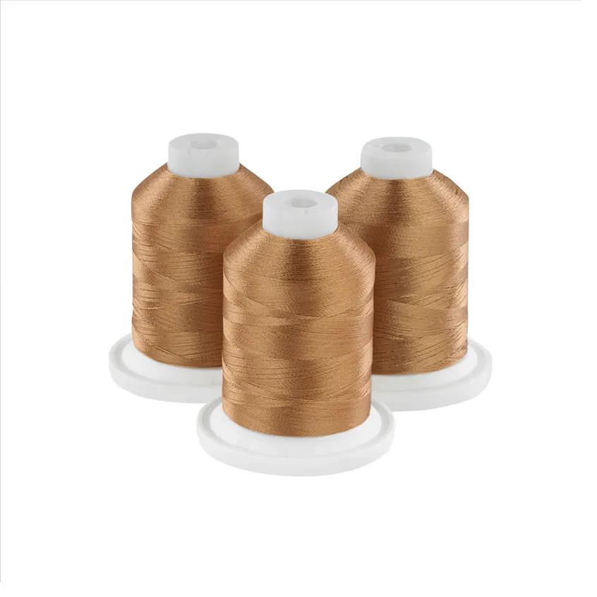 Three amber embroidery thread spools on white bases