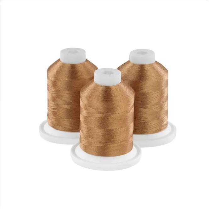 Three amber embroidery thread spools on white bases