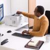 Man retrieving document from Brother HL-L5215DW monochrome laser printer in modern office workspace