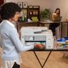 Woman using Brother MFCJ5855DW all-in-one inkjet printer in home office