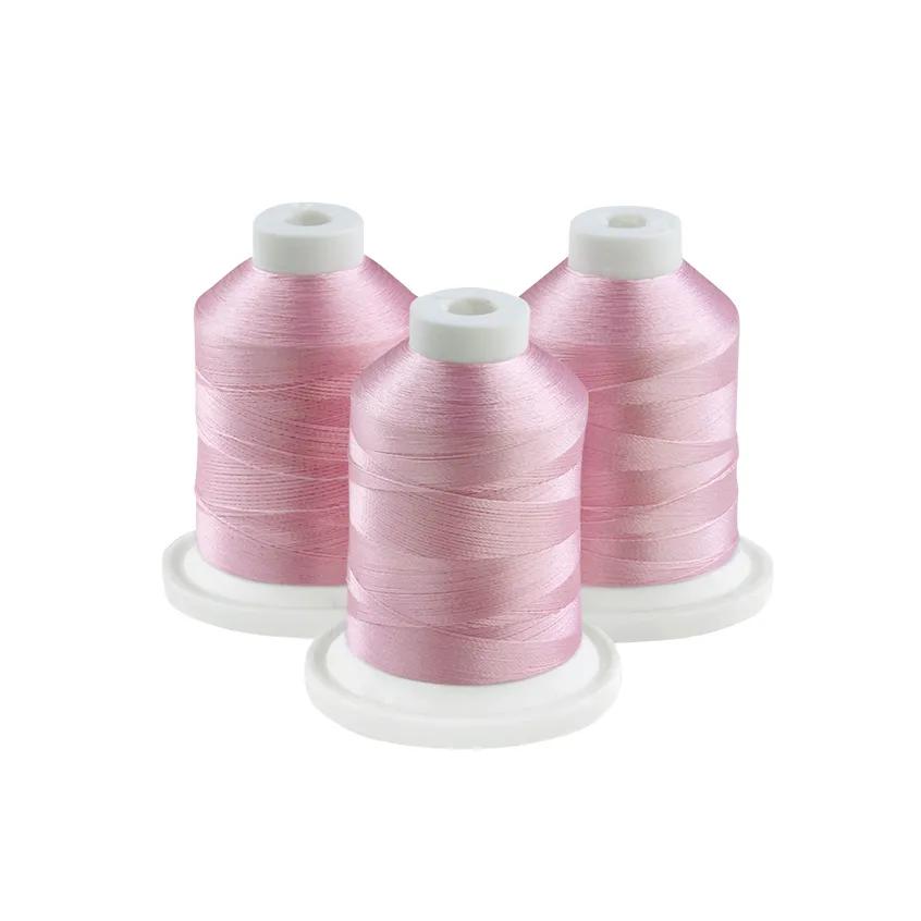 Three spools of pink embroidery thread on white bases