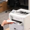 Brother HL-L6415DWT monochrome laser printer with envelope being inserted into manual feed slot