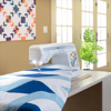 Brother sewing machine quilting blue geometric pattern on table in bright home workspace
