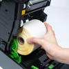 Hand loading yellow label roll into Brother thermal printer with easy drop-in design