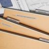 Organized wooden file folders with labeled tabs on a desk with fabric swatches and blueprints