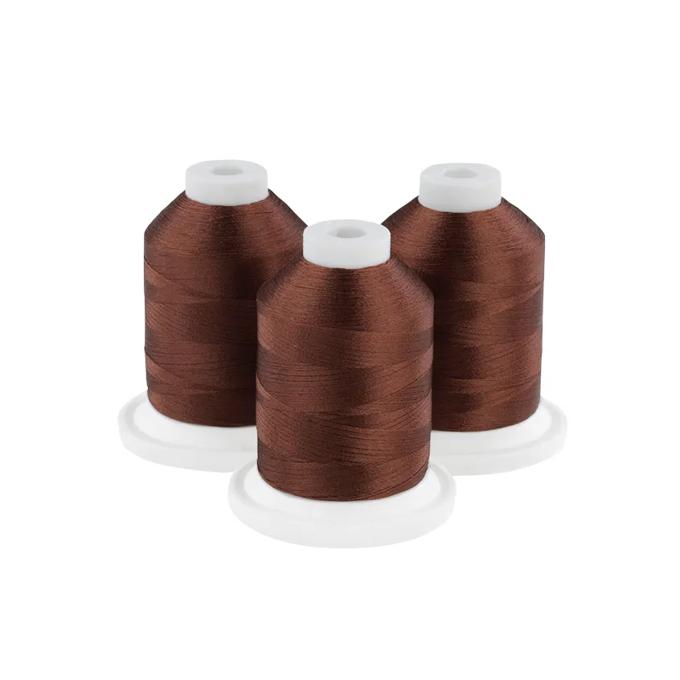 Three hazelnut brown embroidery thread spools on white bases