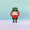 Cartoon leprechaun character with red beard, green hat, and black boots on pastel background