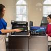 Woman replacing toner cartridge in Brother HL-L8430CDW color laser printer in office
