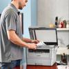Man scanning document on Brother MFCL2759DW monochrome laser all-in-one printer in home office