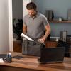 Man placing Brother portable printer into gray messenger bag at home office desk