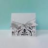 White gift box with decorative damask pattern and silver ribbon bow
