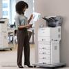 Woman reviewing documents beside Brother laser printer with multi-drawer paper tray in office