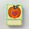 Handmade card with layered paper pumpkin and red heart cutout on polka dot background