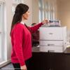 Woman using Brother HL-L8570CDW color laser printer with dual paper trays in office
