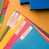Colorful file folders with Brother M-Tape labels for organized office storage