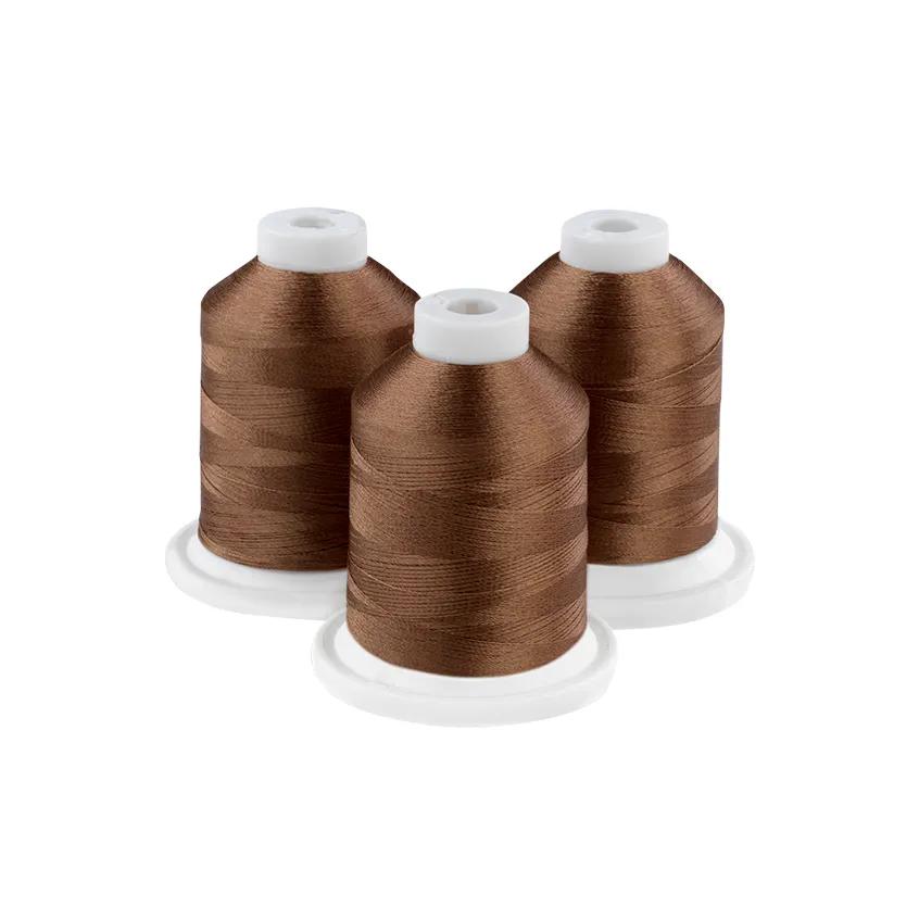 Three spools of sandlewood brown embroidery thread on white background