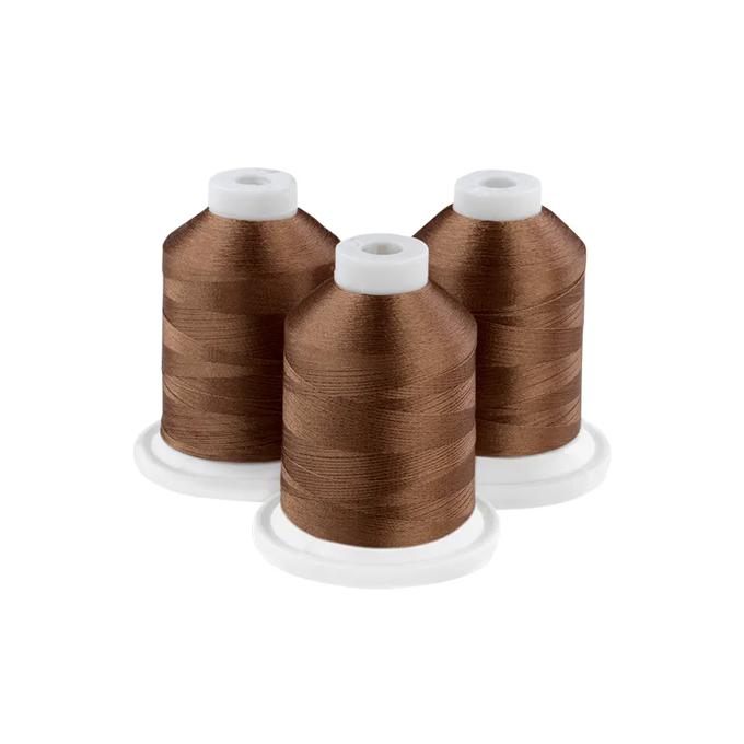 Three spools of sandlewood brown embroidery thread on white background