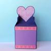 Purple gift box with pink heart decoration and dotted pattern on light blue background