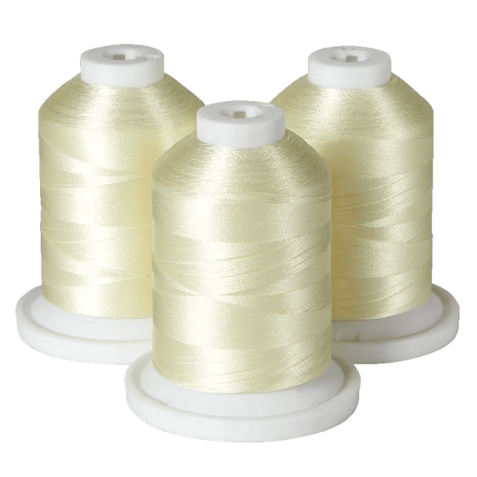 Three spools of pale yellow embroidery thread on white bases