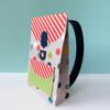 Colorful paper gift bag with red striped flap, polka dots, and black ribbon handle