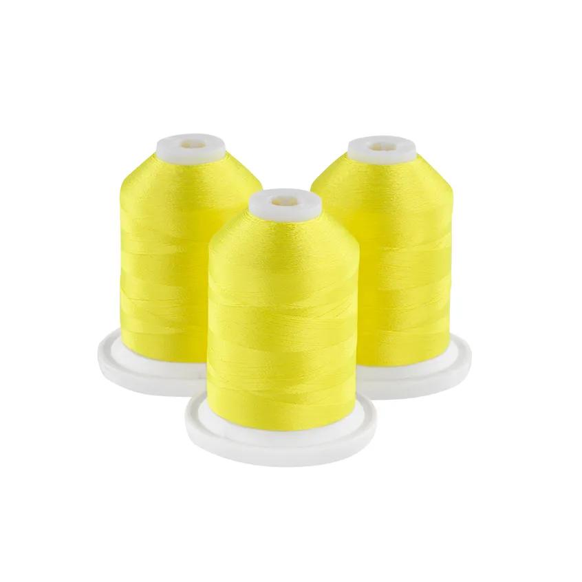 Three bright yellow embroidery thread spools on white bases