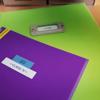 Brother P-touch label on purple folder with green background for office organization