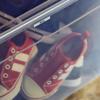 Brother TZe label on clear storage box organizing red canvas sneakers