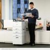 Professional reviewing color reports beside Brother laser printer with high-capacity paper trays