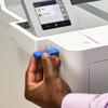 Hand inserting blue USB drive into Brother color laser printer with touchscreen display