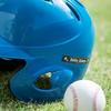 Casco de béisbol azul con etiqueta Brother TZe-345 sobre césped junto a pelota