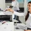 Woman scanning documents on Brother all-in-one color laser printer in modern office
