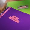 Brother label maker organizing colorful notebooks with custom labels on green desk