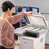 Woman scanning documents on Brother MFC-EX915DW all-in-one printer in office