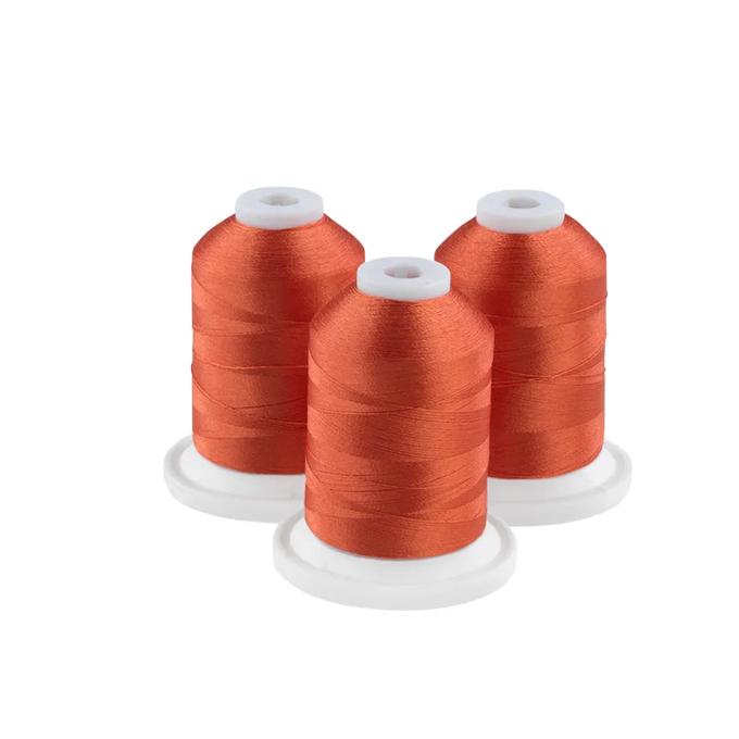 Three rust-colored embroidery thread spools on white bases