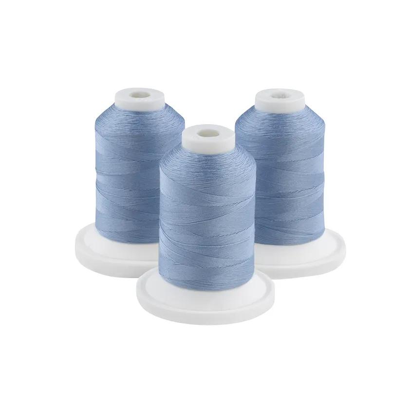 Three spools of Paris blue embroidery thread on white bases