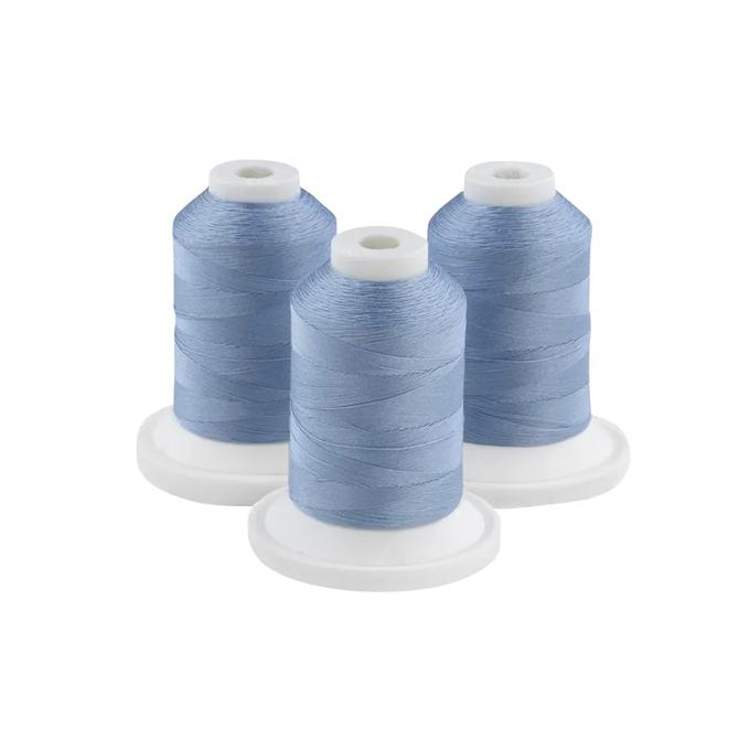 Three spools of Paris blue embroidery thread on white bases