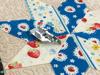 Brother sewing machine presser foot on colorful quilted patchwork fabric with floral patterns