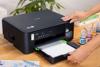 Persona cargando papel en impresora Brother DCP-T430 multifunción con tanque de tinta