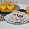 Wooden place card with heart cutout and name on elegant table setting with gold accents